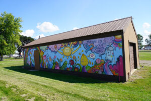 colorful mural on the side of a brown building at 16th St. Park - mural says "move in your own way" on it