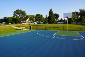 basketball court and a park bench and trail next to it at 23rd St. Park