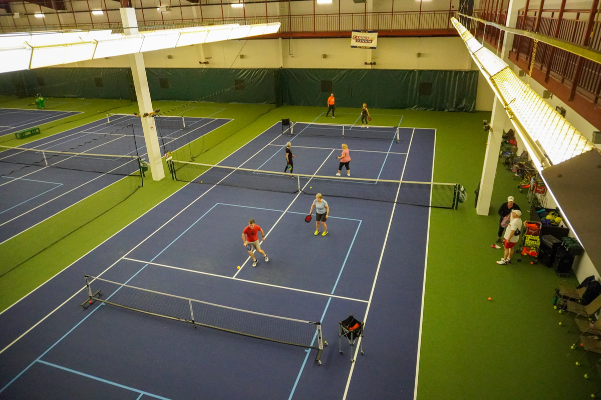 adults playing pickleball on two courts at CRFC