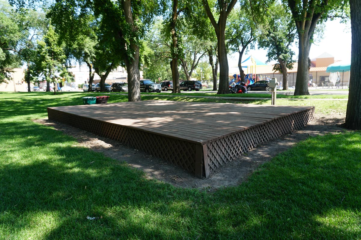reservable stage at Custer Park with grass and trees in background