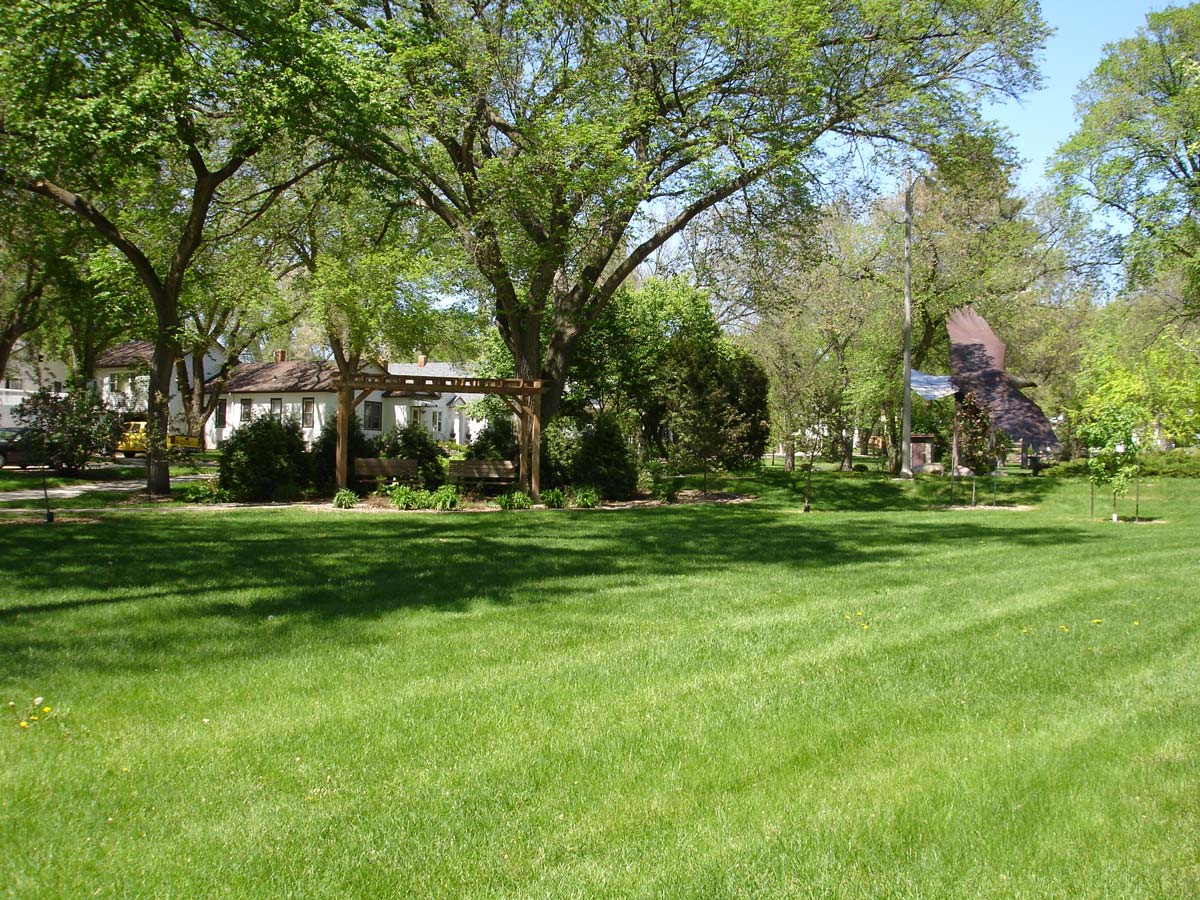 grassy area with park benches and eagle statue at Custer Park