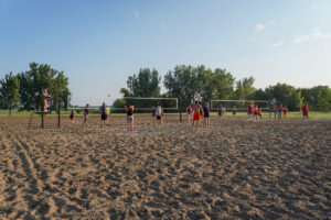 adults playing sand volleyball at Sertoma Park