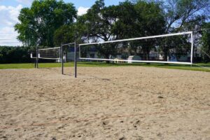two sand volleyball courts with trees in the background