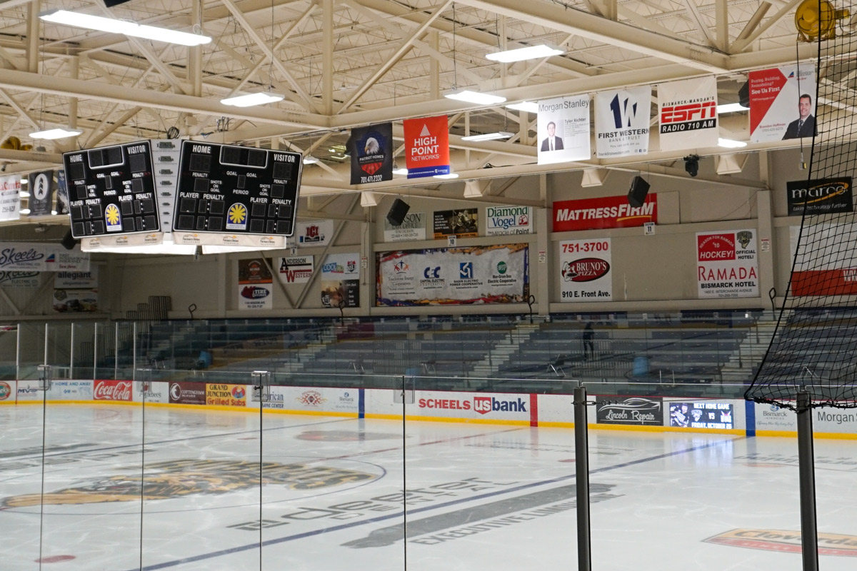 wide angle view of indoor ice arena with bleacher seating