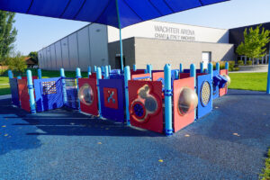 blue and red playground at Wachter Park with Wachter Arena in the background