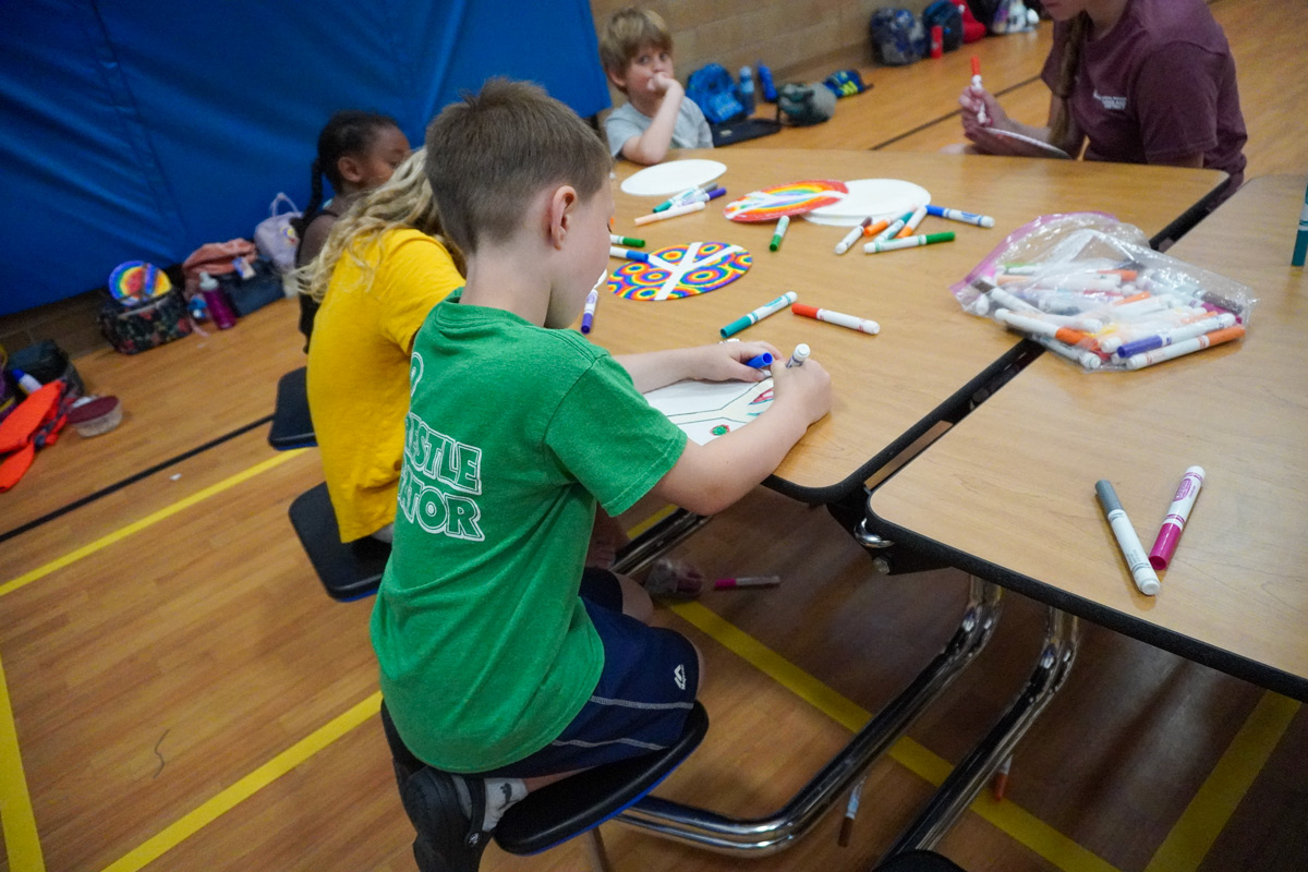 kids coloring with markers at a table